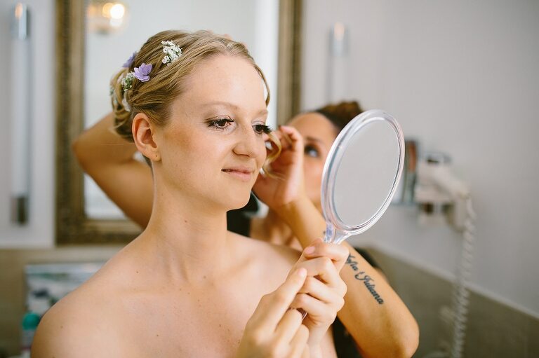 Braut schaut in den Spiegel auf die Haare - Sportschloss Velen