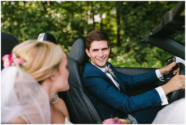 Bräutigam schaut seine Braut im Auto an