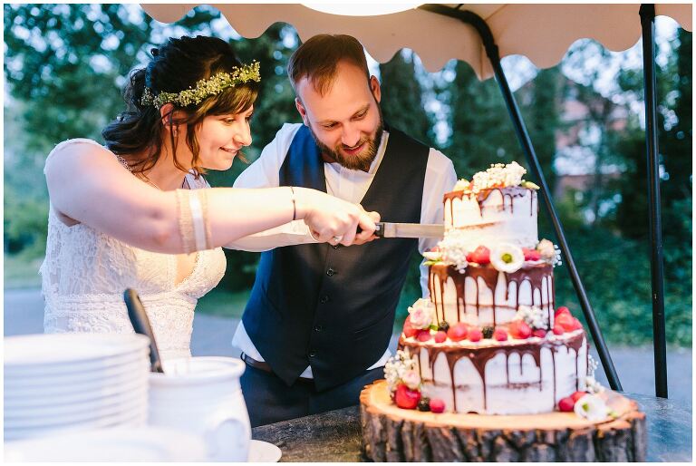 Brautpaar schneidet Hochzeitstorte an