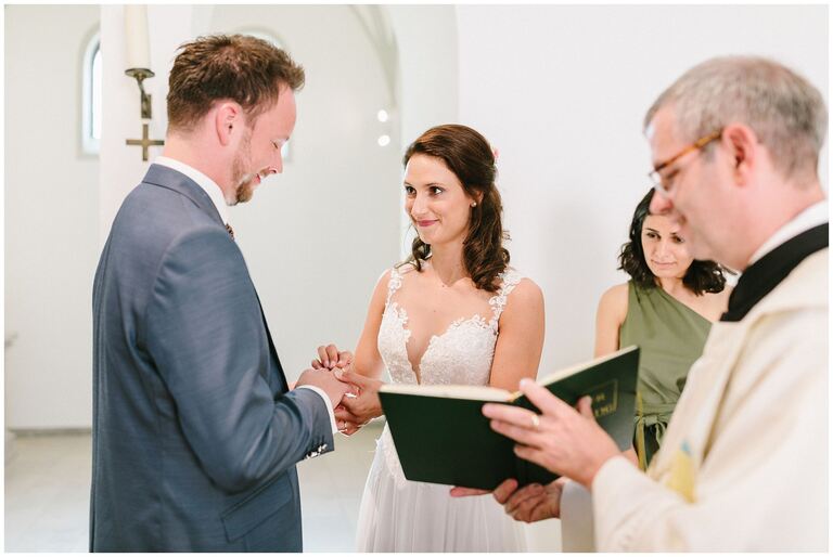 Braut steckt dem Bräutigam den Ring an