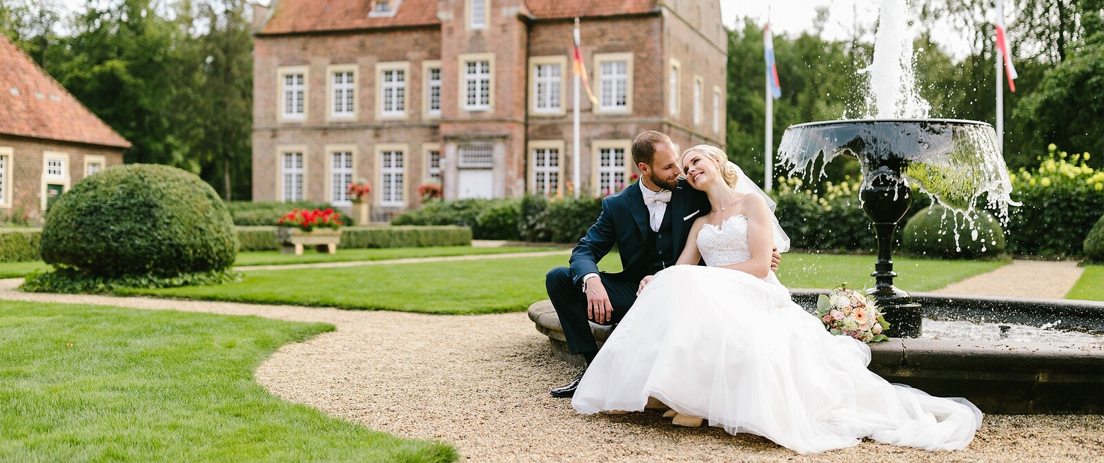 Hochzeitsfotograf Osnabrück mit Hochzeitspaar im Park vor einem Springbrunnen