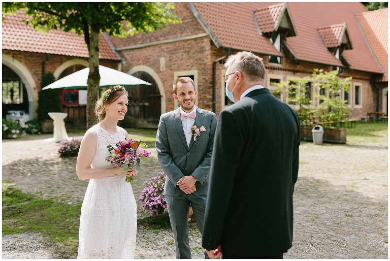 Brautpaar wird vom Standesbeamten begrüßt ©Hochzeitsfotograf Burg Hülshoff