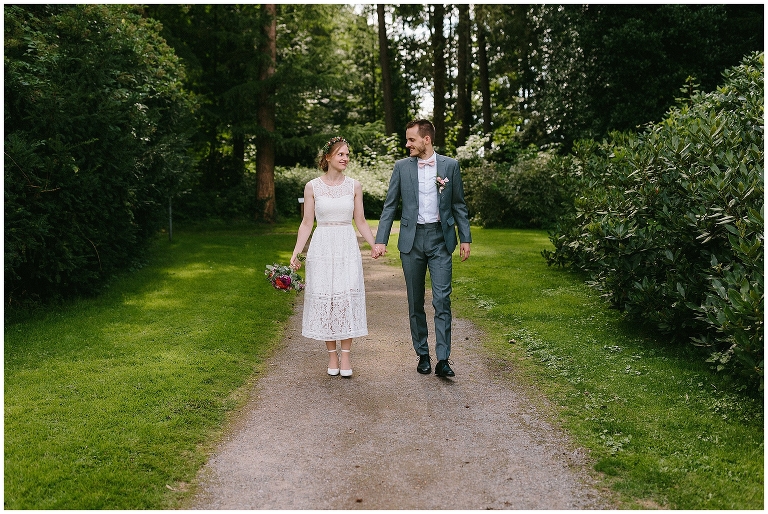 Brautpaar geht im Park spazieren und schaut sich verliebt an ©Hochzeitsfotograf Burg Hülshoff