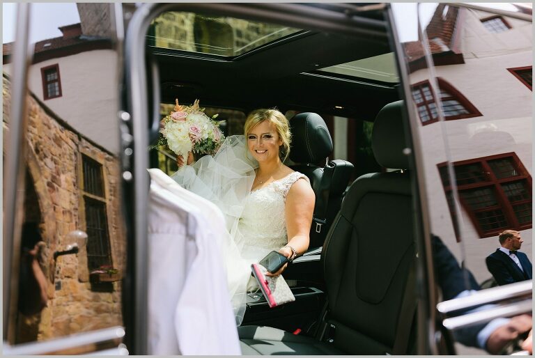 Braut im Auto vor dem Schloss in Bad Iburg ©Hochzeitsfotograf Bad Iburg