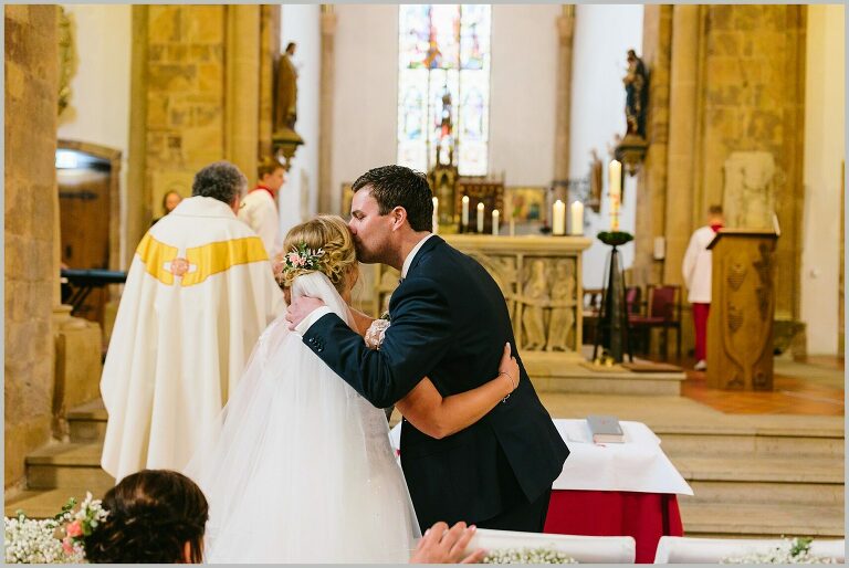 Bräutigam küsst seine Braut in der Kirche ©Hochzeitsfotograf Bad Iburg