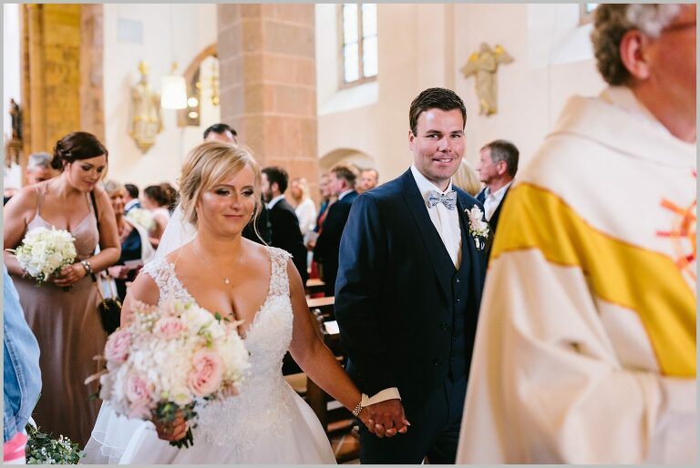 Brautpaar zieht gemeinsam aus der Kirche aus ©Hochzeitsfotograf Bad Iburg