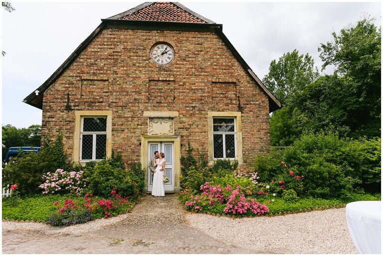 Brautpaar küsst sich vor historischem Gebäude ©Markus Koslowski Hochzeitsfotograf Haus Venne